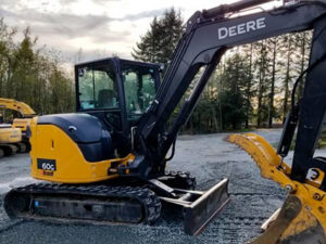 Mini excavator with a thumb in rural BC